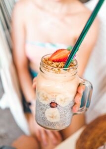 a person holding a glass of smoothie